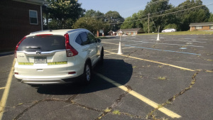 A driving student weaves the car between the cones.