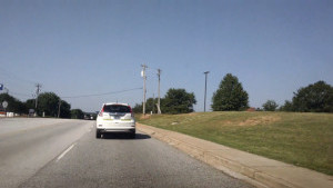 A student drives down a four-lane road in the drivers education car with Mr. Sabbadino.