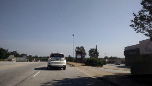 A driving student uses his blinker before changing lanes.