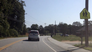 A student drives down a two-lane road in the drivers education car with Mr. Sabbadino.