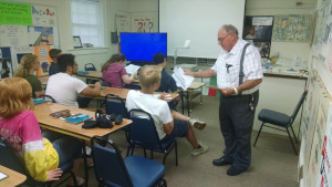 Mr. Sabbadino hands out a piece of paper to each of his students.