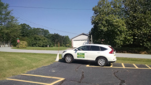 A driving student eases the car forward until the from bumper touches the cone.